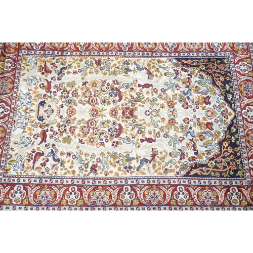 692 - Middle Eastern carpet rug having a white arched panel to centre decorated with florals and fauna wit... 