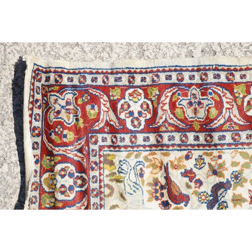 692 - Middle Eastern carpet rug having a white arched panel to centre decorated with florals and fauna wit... 