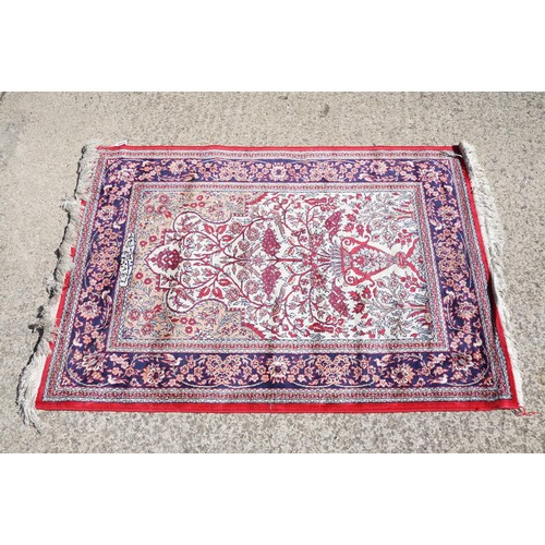 694 - Middle Eastern carpet rug having a central panel to centre decorated with a central urn and florals ... 