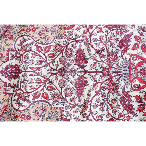 694 - Middle Eastern carpet rug having a central panel to centre decorated with a central urn and florals ... 