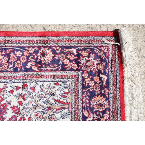 694 - Middle Eastern carpet rug having a central panel to centre decorated with a central urn and florals ... 