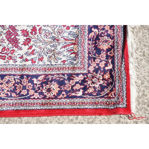 694 - Middle Eastern carpet rug having a central panel to centre decorated with a central urn and florals ... 