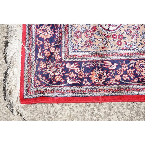 694 - Middle Eastern carpet rug having a central panel to centre decorated with a central urn and florals ... 