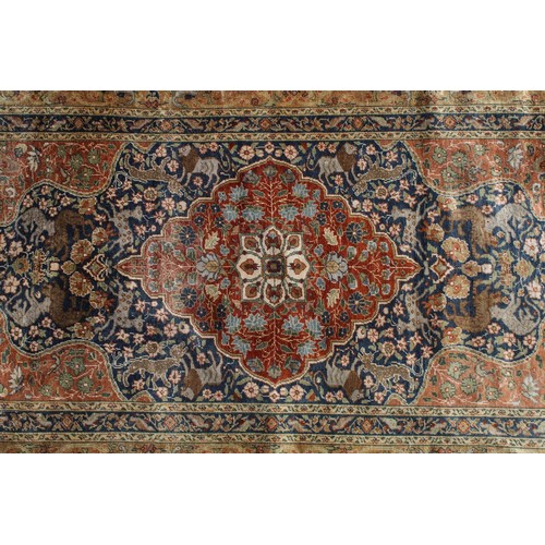 695 - Middle Eastern carpet rug having a central medallion red medallion within a blue flora and fauna dec... 