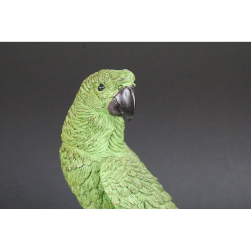 135 - Model of a green parrot on a perch mounted on a turned wooden base, 43cm high