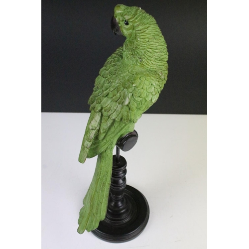 135 - Model of a green parrot on a perch mounted on a turned wooden base, 43cm high