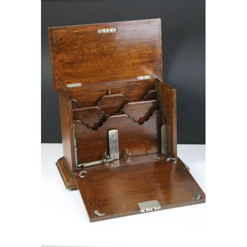 146 - Early 20th century oak stationery box with key, the fall front revealing carved sections, with three... 