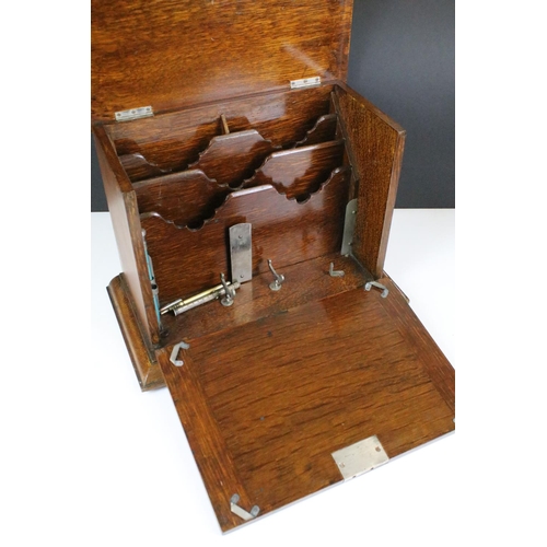 146 - Early 20th century oak stationery box with key, the fall front revealing carved sections, with three... 