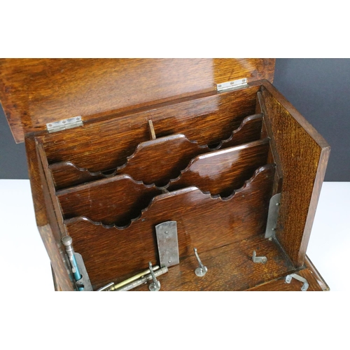 146 - Early 20th century oak stationery box with key, the fall front revealing carved sections, with three... 