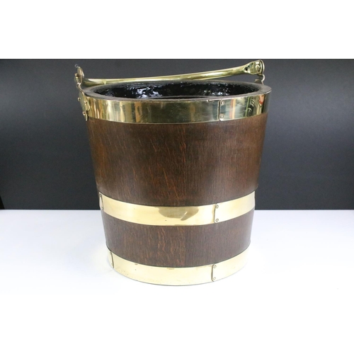 154 - Edwardian oak coal bucket with brass banding together with a hammered brass example. Bucket measures... 