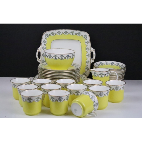 114 - Royal Stafford yellow ground floral china tea set, marked 4895, to include 12 cups & saucers, 12 tea... 
