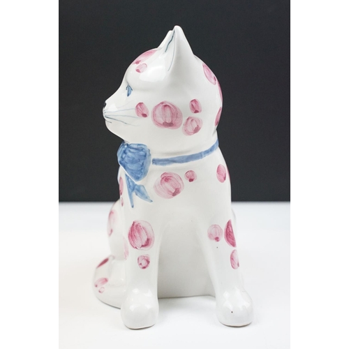 19 - Pair of Rye pottery models of seated cats, white with pink spots wearing blue bows, 20cm high