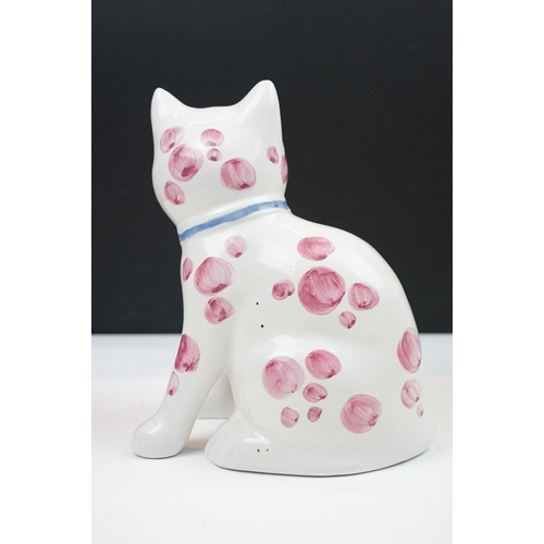 19 - Pair of Rye pottery models of seated cats, white with pink spots wearing blue bows, 20cm high