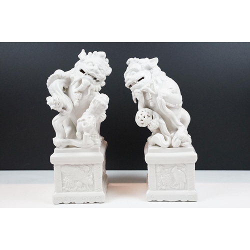 23 - Pair of Chinese white ceramic mythical lions (approx 33cm tall), together with a Guan Yin ceramic fi... 
