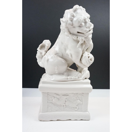 23 - Pair of Chinese white ceramic mythical lions (approx 33cm tall), together with a Guan Yin ceramic fi... 