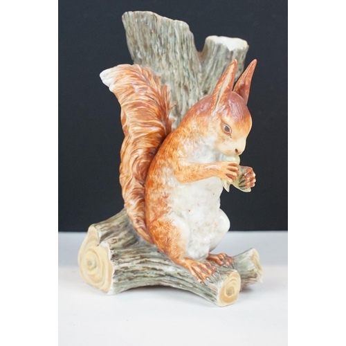 72 - Royal Worcester porcelain figure of a red squirrel modelled seated by a tree stump eating a nut, imp... 