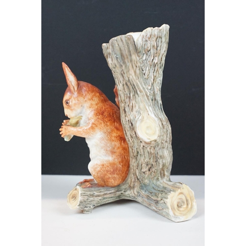 72 - Royal Worcester porcelain figure of a red squirrel modelled seated by a tree stump eating a nut, imp... 