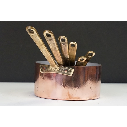 111 - Graduating set of six copper saucepans with brass handled, together with a larger saucepan & cover (... 