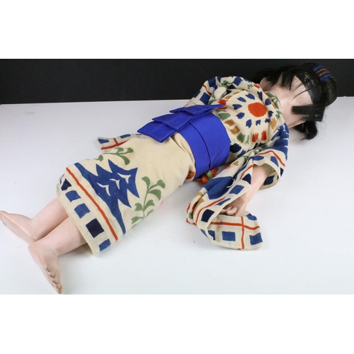 113A - A large Japanese articulated doll in traditional dress, stands approx 60cm in height