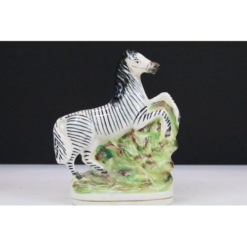 16 - Pair of Staffordshire rearing zebra porcelain figures on a naturalistic ground, 16cm high, together ... 