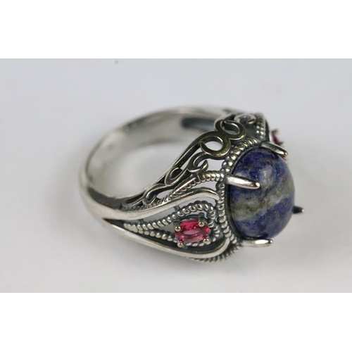 162 - A 925 sterling silver ladies dress ring with central blue stone and decorative shoulders.