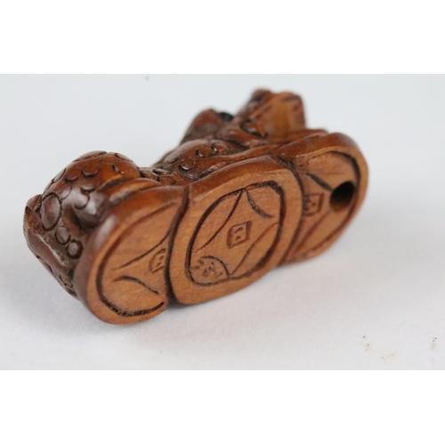 166 - Three carved wooden miniature netsuke figures to include signed Dog, Ox and Money Dragon