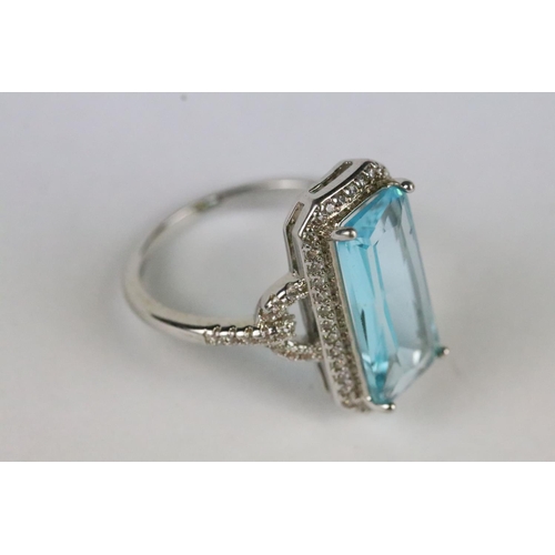 167 - A ladies 925 sterling silver dress ring with central blue stone and decorative pierced shoulders, ma... 