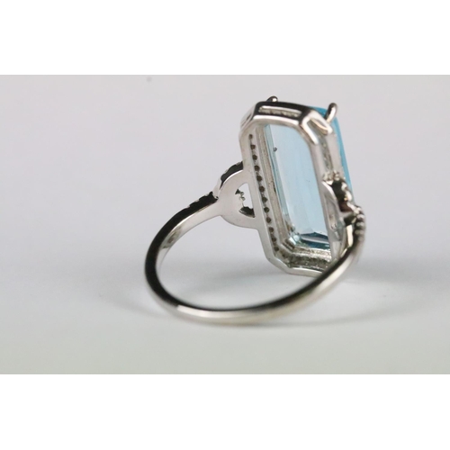 167 - A ladies 925 sterling silver dress ring with central blue stone and decorative pierced shoulders, ma... 