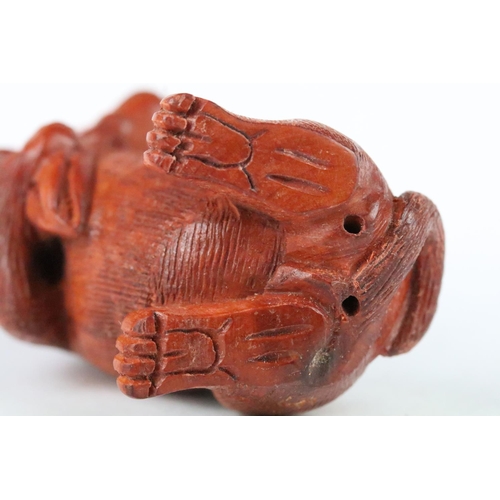 170 - Two carved wooden netsuke figures to include a signed Dog chewing toy, and a Money Dragon on Coin, t... 