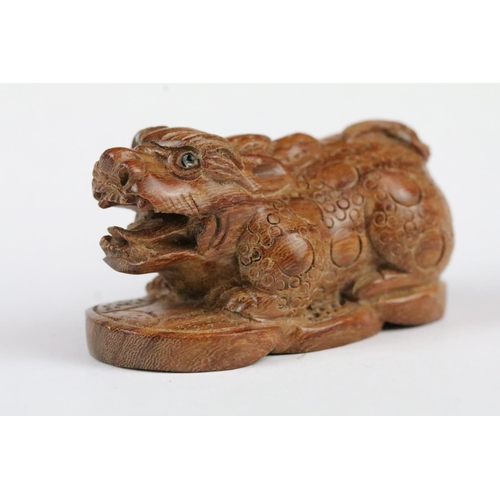 170 - Two carved wooden netsuke figures to include a signed Dog chewing toy, and a Money Dragon on Coin, t... 