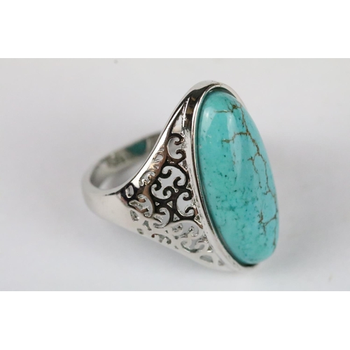 176 - A ladies 925 sterling silver ring with central turquoise cabochon, pierced decoration to shoulders, ... 