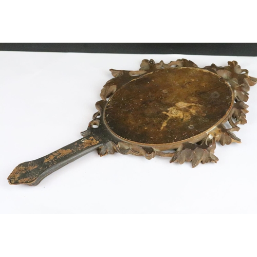 193 - An antique black forest hand mirror with oak leaf and acorn decoration.