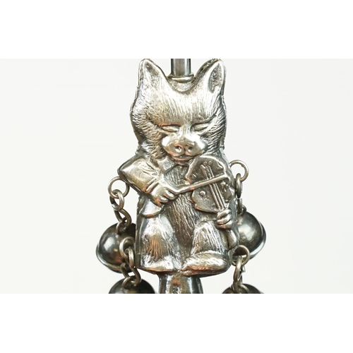 234 - A white metal babies rattle in the form of a cat playing the fiddle, mounted to blackened wooden han... 