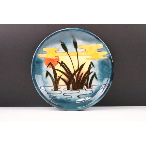 25 - Moorcroft Pottery Reeds at Sunset plate, with tube lined decoration, 26cm diameter, impressed mark t... 