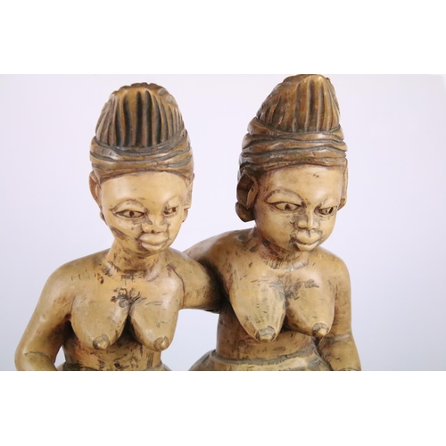 262 - Large African carved hardwood figure of two women and two children sitting on a face mask, 113cm hig... 