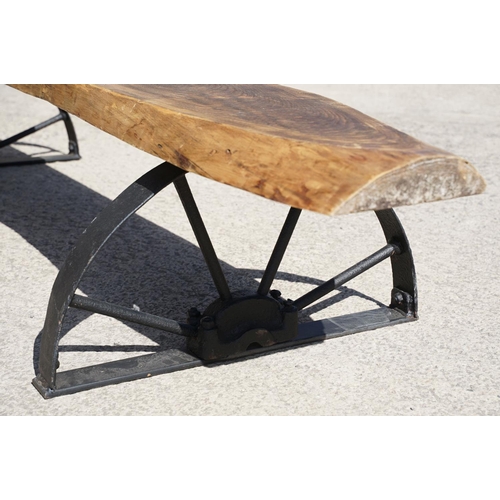 289 - A large contemporary pine single plank garden bench, mounted to two semi circular wrought iron legs,... 