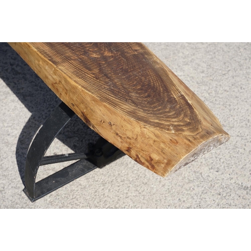 289 - A large contemporary pine single plank garden bench, mounted to two semi circular wrought iron legs,... 