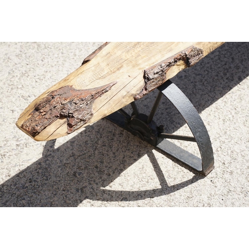 289 - A large contemporary pine single plank garden bench, mounted to two semi circular wrought iron legs,... 