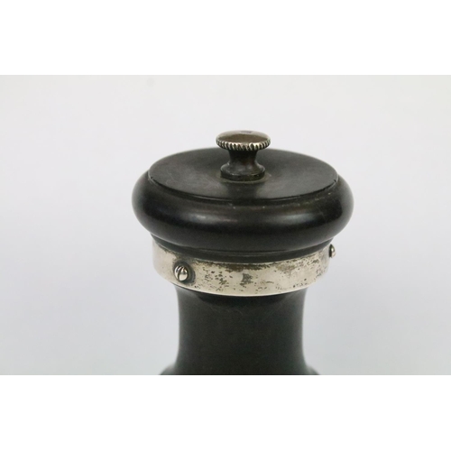 29 - An ebonised wooden pepper mill with fully hallmarked sterling silver collars, assay marked for Birmi... 