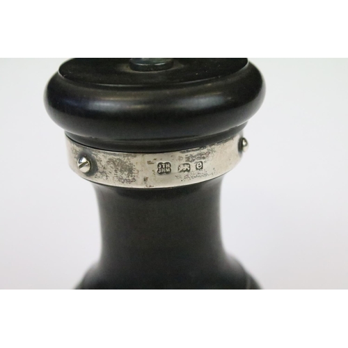 29 - An ebonised wooden pepper mill with fully hallmarked sterling silver collars, assay marked for Birmi... 