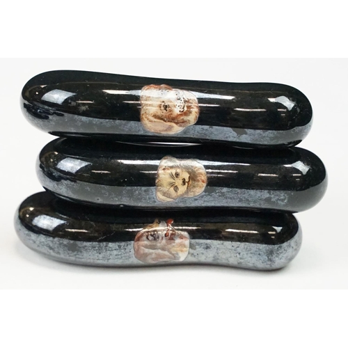 322 - A collection of ten black ceramic parasol handles with transfer decoration of dogs