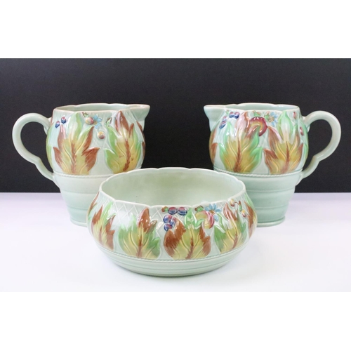 34 - Clarice Cliff for Newport Pottery - Pair of leaf & berry pattern molded jugs on a celadon type groun... 