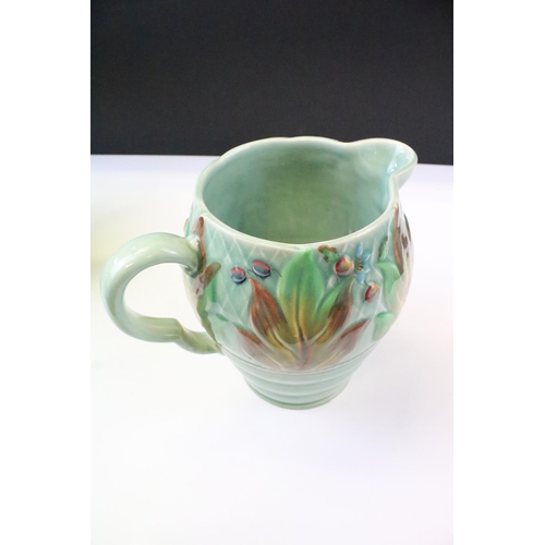 34 - Clarice Cliff for Newport Pottery - Pair of leaf & berry pattern molded jugs on a celadon type groun... 