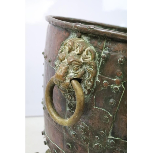 45 - Victorian riveted copper log basket with twin lion mask handles, on four claw feet, 43cm high x 50cm... 