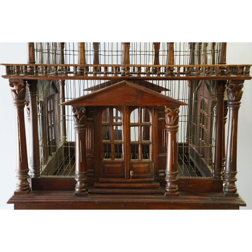 369 - Ornamental mahogany bird cage in the form of a building, on stand, approximately 216cm high x 67.5cm... 