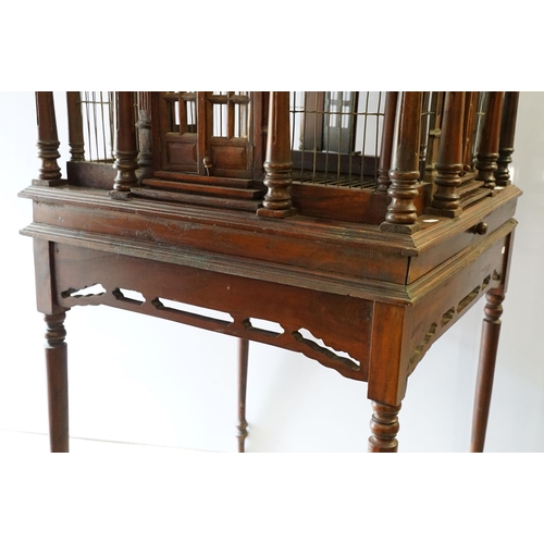 369 - Ornamental mahogany bird cage in the form of a building, on stand, approximately 216cm high x 67.5cm... 