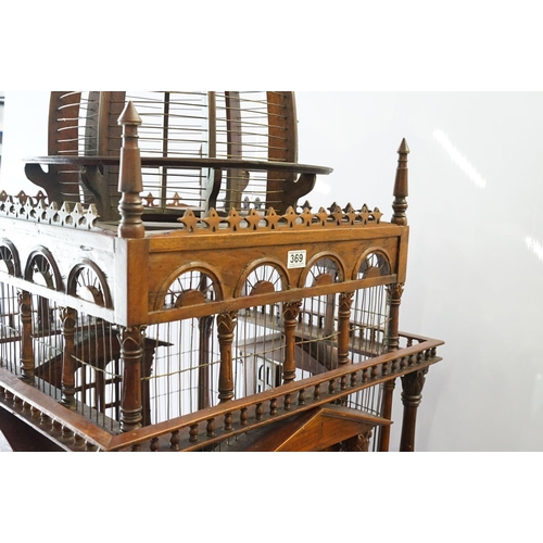 369 - Ornamental mahogany bird cage in the form of a building, on stand, approximately 216cm high x 67.5cm... 