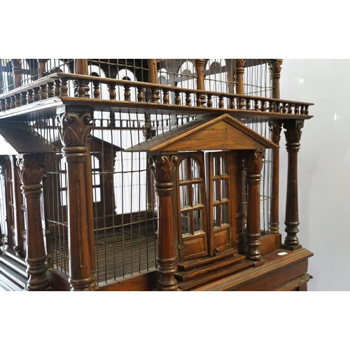 369 - Ornamental mahogany bird cage in the form of a building, on stand, approximately 216cm high x 67.5cm... 