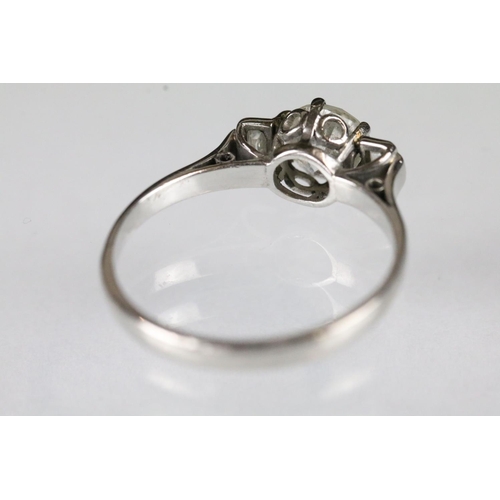 42 - Platinum and diamond three stone ring being set with a round brilliant cut diamond to centre flanked... 