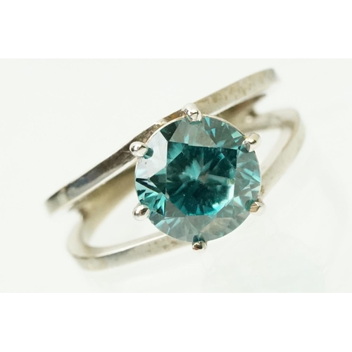 14 - 18ct white gold and zircon dress ring. The ring being set with a round brilliant cut blue zircon pro... 